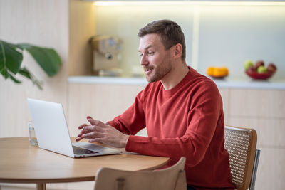 Portrait of young woman using laptop at home