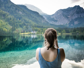 Rear view of woman standing at lakeshore