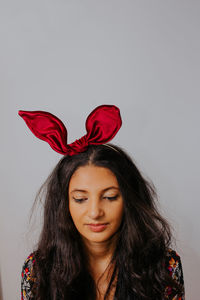 Portrait of beautiful woman against red background