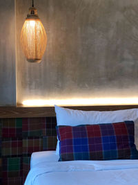 Close-up of illuminated lamp hanging on wall at home