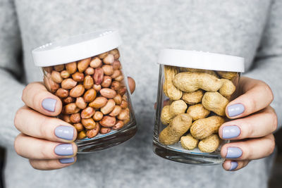 Close-up of hand holding peanut jars