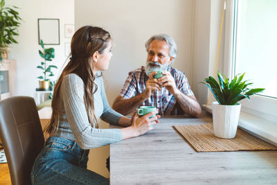 Young woman using mobile phone while sitting at home