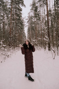 Full length of woman standing on snow covered land