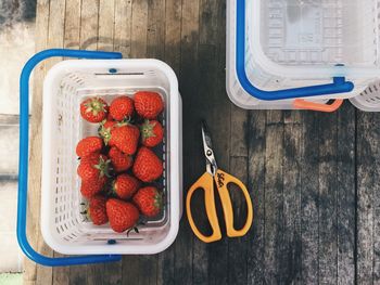 High angle view of strawberries in plastic basket on table