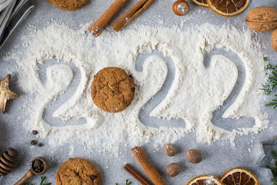 Christmas background with spices, cookies and painted number 2022 on flour. happy new year