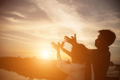 Silhouette people standing against sky during sunset