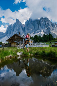 Reflection of man in lake against mountains