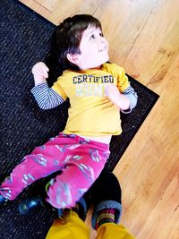 High angle view of girl sitting on hardwood floor