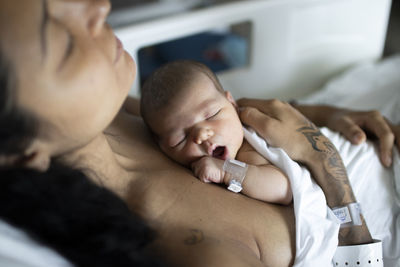 A newborn sleeping in the hospital with her mun