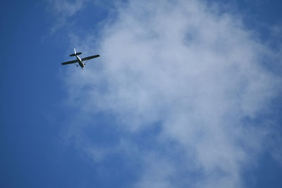 Low angle view of airplane flying in blue sky