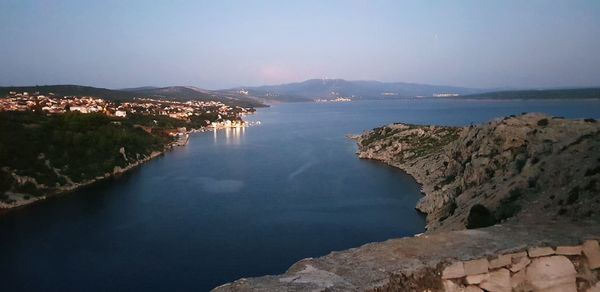 High angle view of sea by city against sky