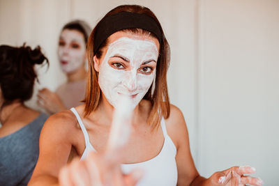 Portrait of young woman with facial mask