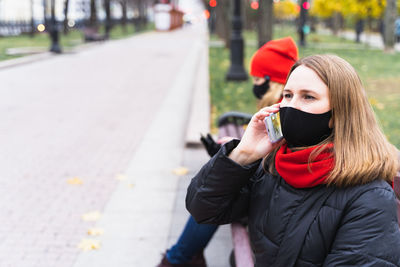 Young woman looking away in city during winter