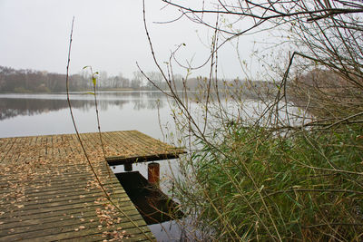 Wooden post on lakeshore against sky