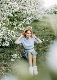 Beautiful pretty young woman walks enjoying the aroma of blooming apple flowers in a spring park