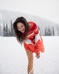 Stylish young woman laughs in the snow