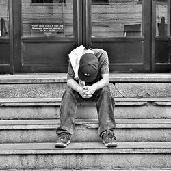 Rear view of a man sitting on window