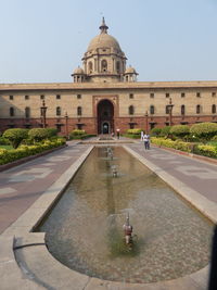 Fountain in front of building against clear sky