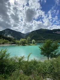 Scenic view of lake by mountains against sky