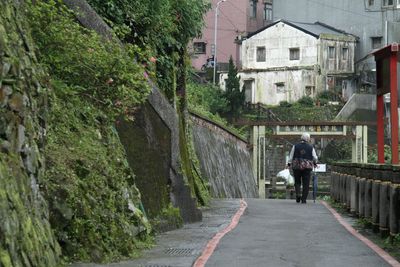 Rear view of woman walking on footpath