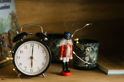 Christmas card toy nutcracker, alarm clock on the background of christmas lights
