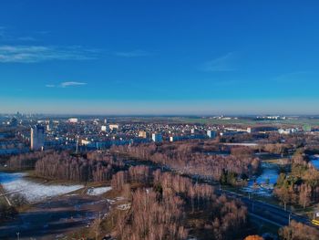 High angle view of river amidst buildings against blue sky