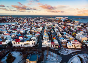 High angle view of townscape by sea against sky