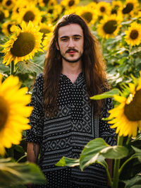 Portrait of smiling woman standing in sunflower