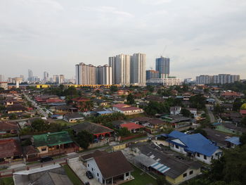 Aerial view of buildings in city against sky