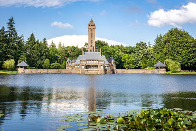 View of building by lake against sky