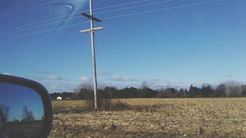 Electricity pylon on field against sky