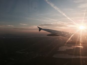 Airplane flying in sky during sunset