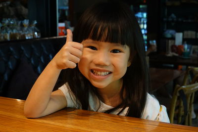 Portrait of smiling boy on table at restaurant