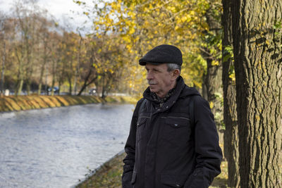 Young man standing against lake