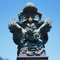 Low angle view of statue against clear blue sky