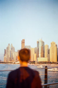 Rear view of man standing against clear sky