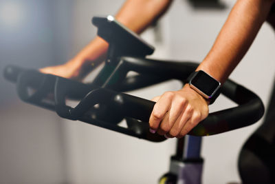 Cropped image of woman on exercise bike in gym