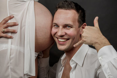 Portrait of man listening to pregnant woman abdomen