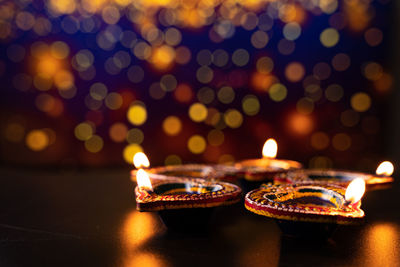 Close-up of illuminated candles on wall