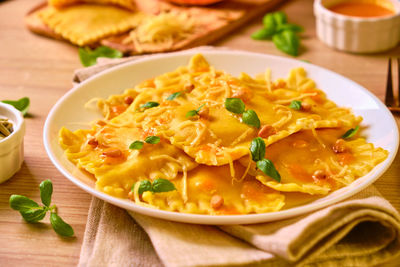 Homemade pumpkin ravioli with ricotta cheese served basil