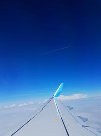 Low angle view of airplane flying against blue sky