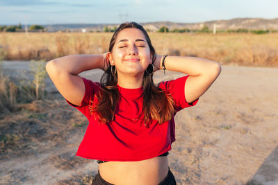 Happy teenager touching her hair in the countryside feeling free