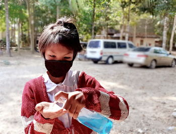 Girl washing hands while standing outdoors