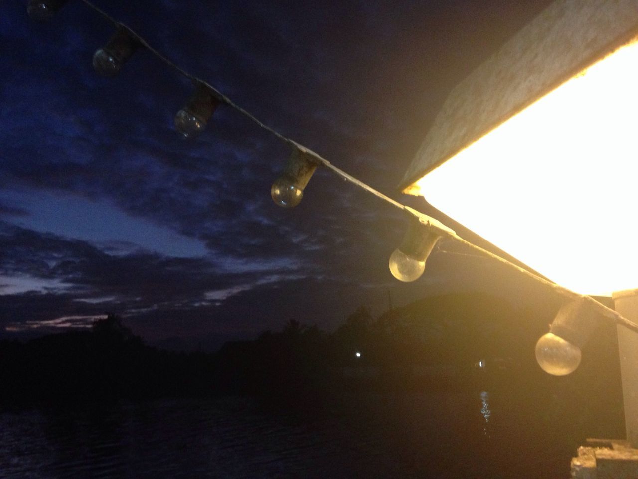 low angle view, night, sky, illuminated, built structure, architecture, water, lighting equipment, reflection, moon, nature, dusk, no people, outdoors, street light, connection, electricity, cloud - sky, weather