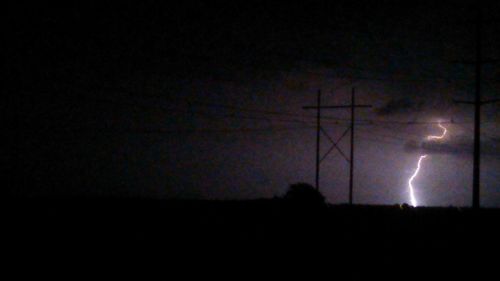 Silhouette of lightning in sky at night