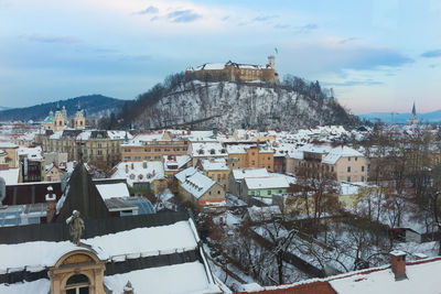 Buildings in town against sky during winter