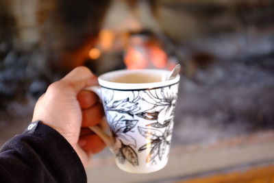 Close-up of hand holding coffee cup