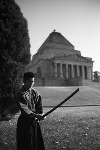 Man standing by built structure against clear sky