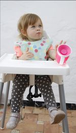 Portrait of cute girl sitting on chair