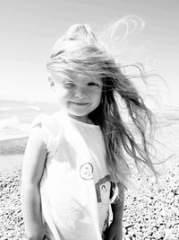 Portrait of girl with tousled hair standing at beach